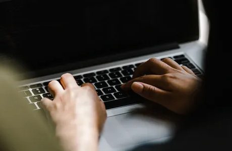 A person typing on a laptop computer.